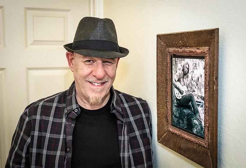 Michael Ely stands next to a photo of his spouse, James "Spider" Taylor — Photo courtesy of Michael Ely