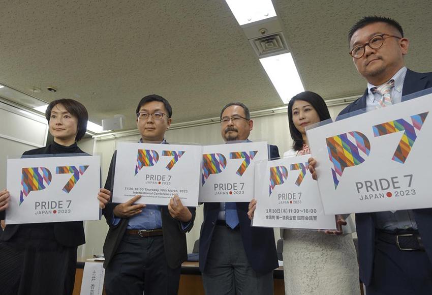 LGBTQ activists in Tokyo, holding cards for civil engagement group Pride7 — Photo by Mari Yamaguchi / AP