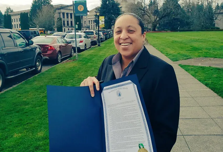 Monisha Harrell pictured in March 2020 with Senate resolution 8694 that goes along with House bill 1687 also known as the Nikki Kuhnhausen Act, which removes a legal strategy known as the LGBTQ+ panic defense – Photo courtesy of Equal Rights WA