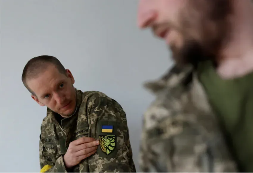 Antonina Romanova (left) and Oleksandr Zhuhan wear a unicorn insignia on their uniforms – Photo by Edgar Su / Reuters