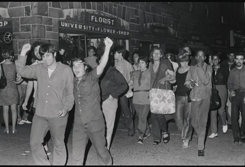 Gay Liberation Front members Jerry Hoose (left), Mark Segal (right), and Sylvia Rivera (background, holding a bag) at a GLF demonstration against New York University – Photo by Diana Davies collection, New York Public Library