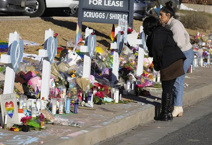 Mourners in front of a roadside memorial for the victims of the Club Q shooting – Photo by David Zalubowski / AP