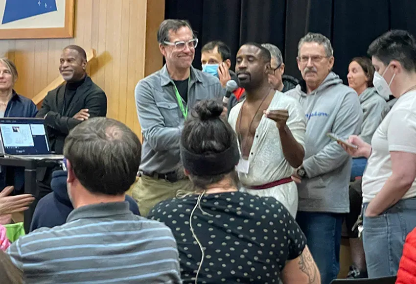 Andy Sheffer, project manager with Seattle Department of Parks and Recreation holds the mic as community members line up to speak against the proposed children's play area – Photo by Teddy MacQuarrie